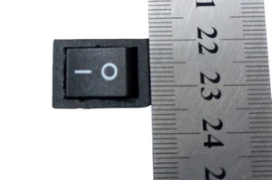 14MMX20MM 2 Position Rocker Switch 4 Legs - shown in a top-down view next to a metal ruler to indicate its size.