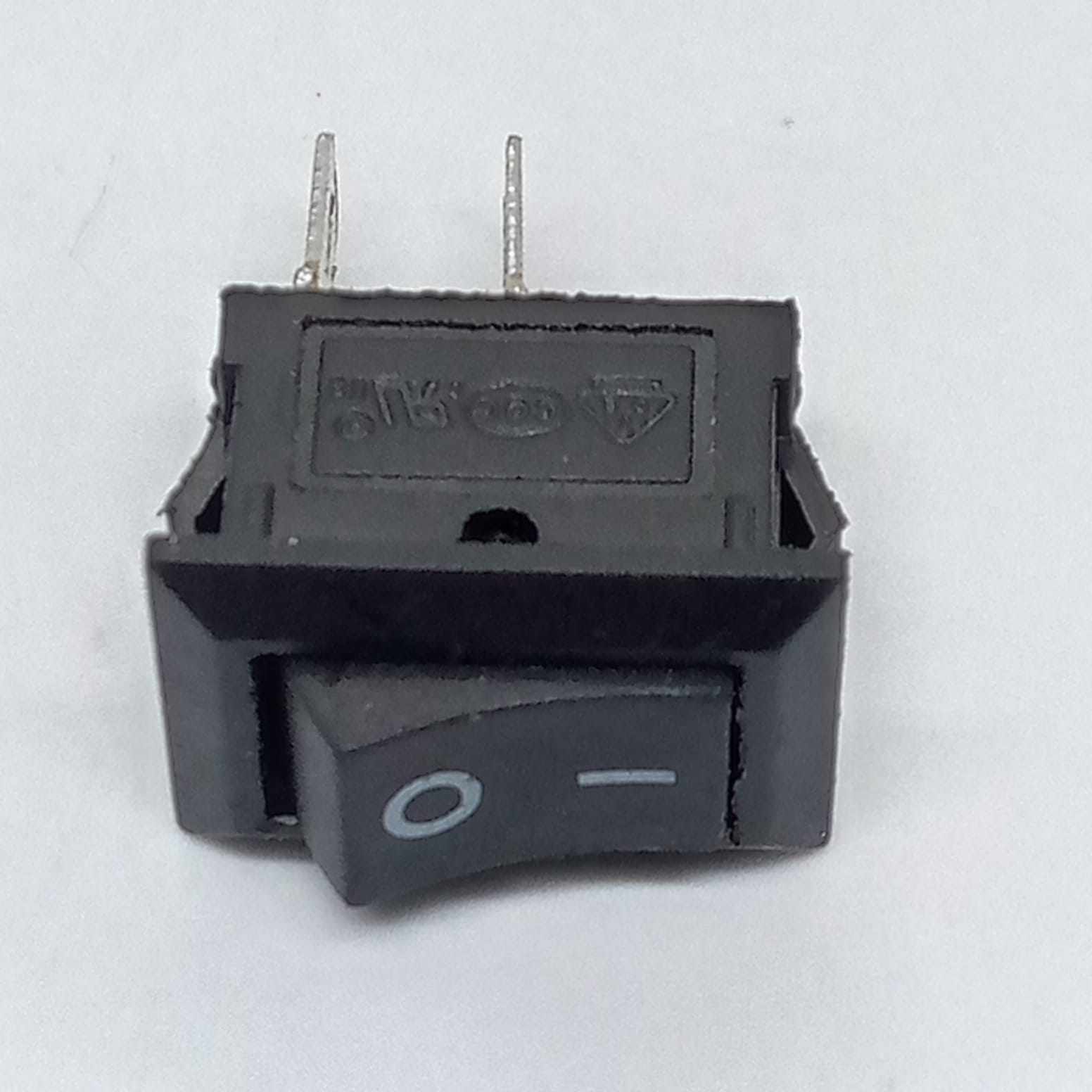 15MMX10MMX8MM KCD11 Rocker Switch 3A - a small black rectangular rocker switch with two metal pins and an O-I power symbol on the button.