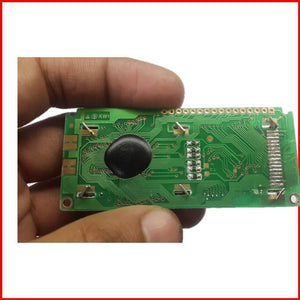 1601 LCD 16x1 LCD 16×1 Character LCD Without Back Light Display - rear view showing a green rectangular circuit board with a black epoxy-covered chip, surface-mount components, and pins.