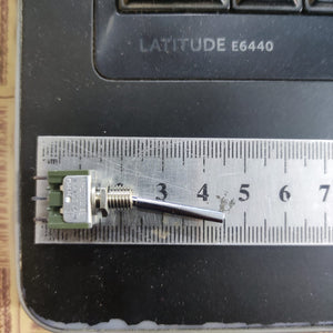 2 Position Long Toggle Switch Frsky Taranis - shown in a top-down close-up view with a metal ruler for scale, displaying its silver lever and green base.