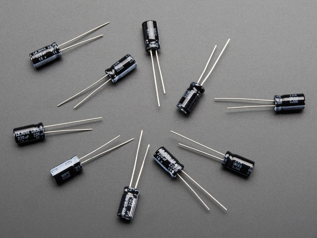 220uF 16V Electrolytic Capacitors - shown as a flat-lay arrangement of ten small, black, cylindrical electronic components with two metal wire leads each.