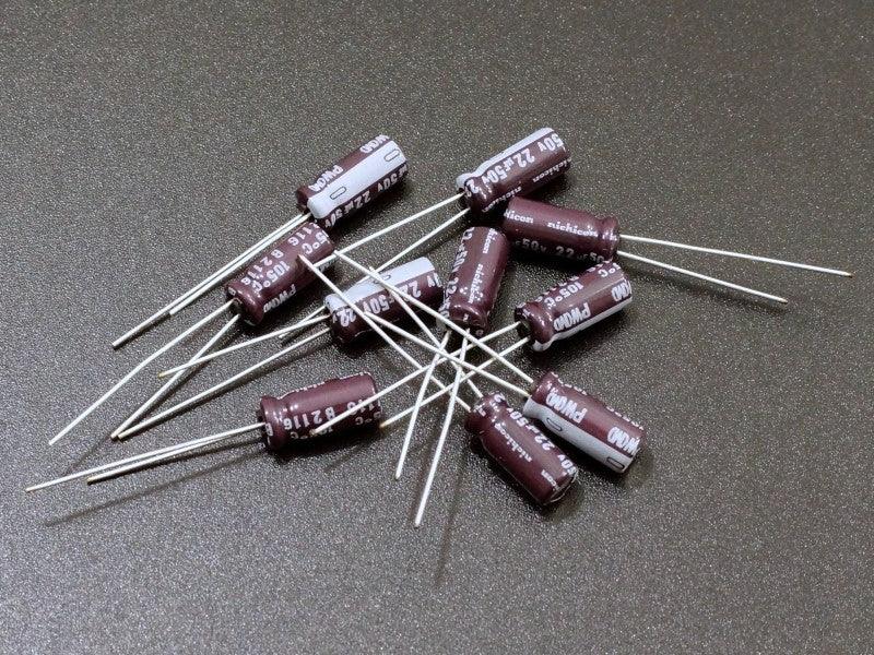 22uF 50V Electrolytic Capacitor - shown as a pile of small, brown, cylindrical radial lead components with white markings on a dark surface.