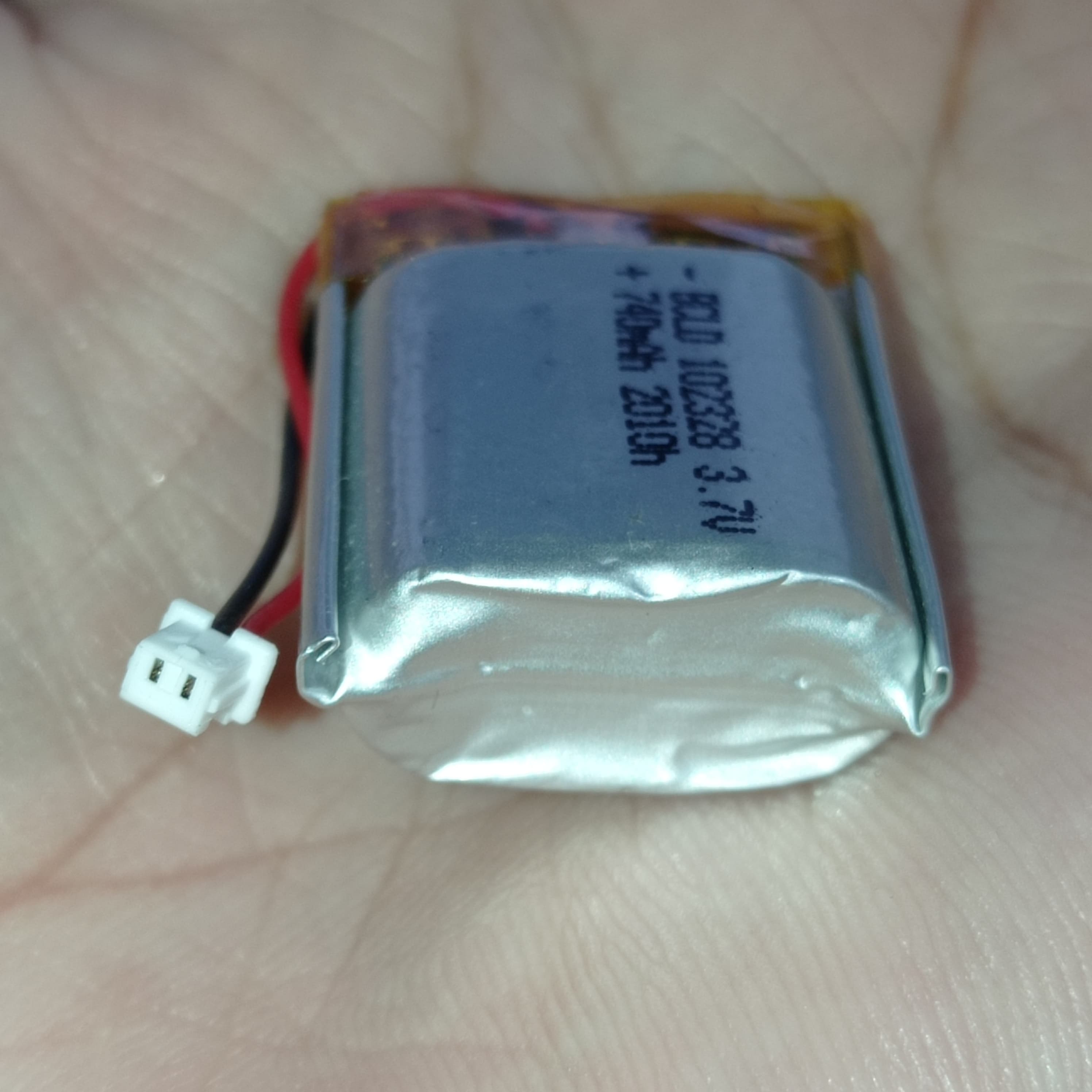 23mm x 28mm x 10mm 3.7V 740mA Li Ion Battery - a silver rectangular lithium-ion battery with a two-pin white connector and red and black wires.