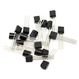 2N2222A Bipolar Junction NPN Transistor - a pile of black, three-legged electronic components with silver pins scattered on a white background.