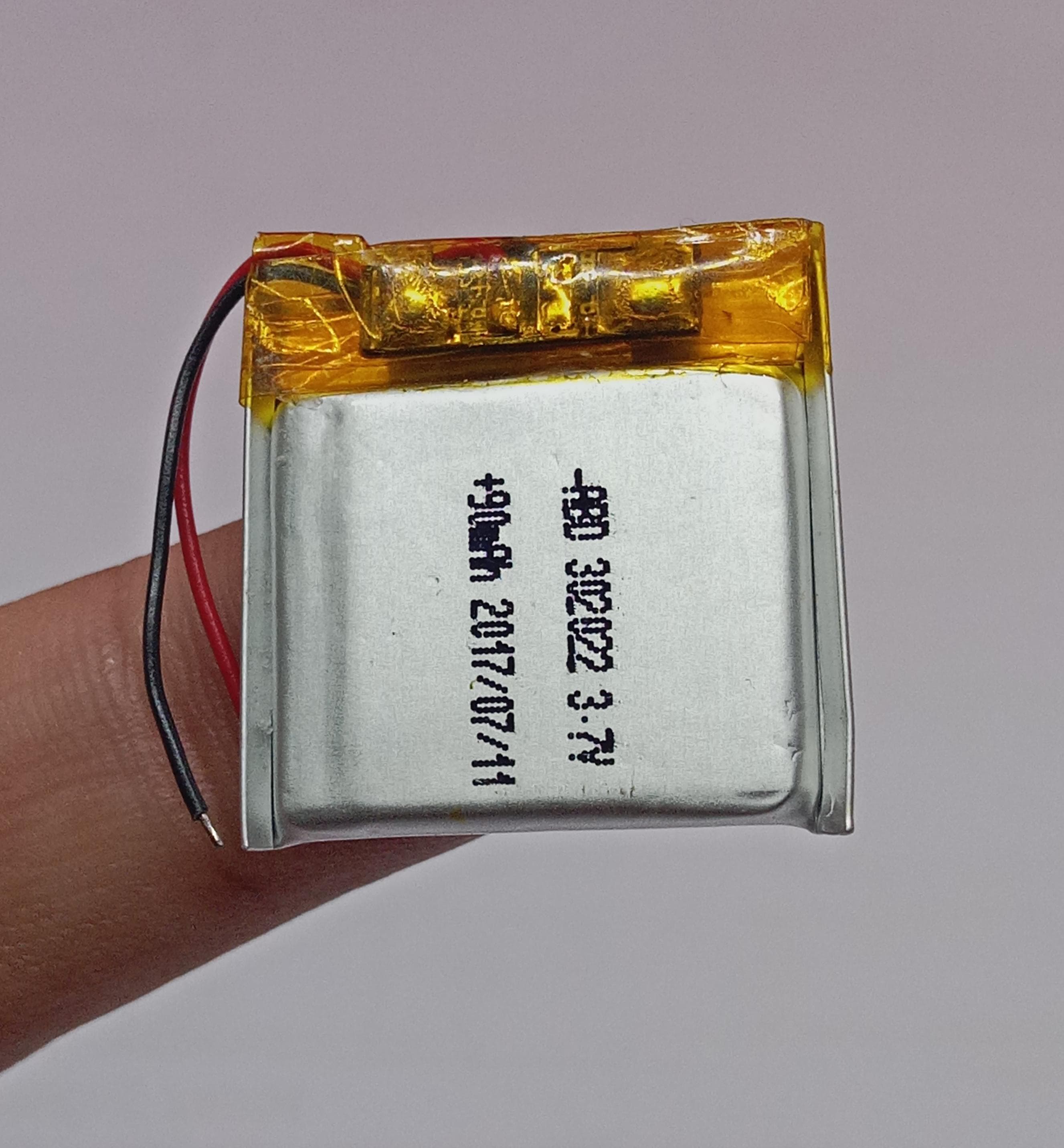 3.7V 90mAh Lithium Ion Li-ion Battery - a small square silver cell with red and black wires and a protective circuit board wrapped in yellow tape.