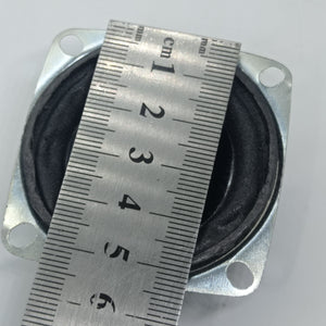 4 Ohm 5 Watt Speaker - shown from a top-down perspective with a metal ruler placed across it to demonstrate its diameter in centimeters.