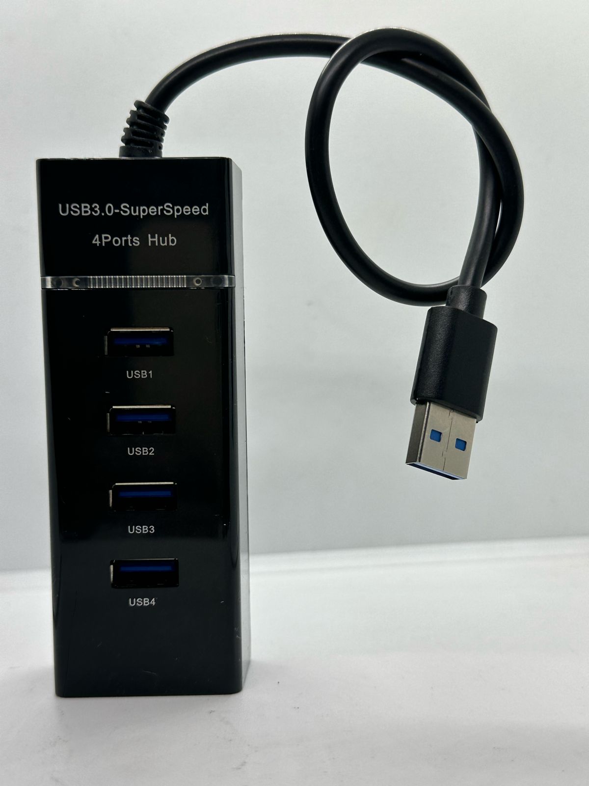 4 Port USB Hub Hi-speed USB 3.0 - a black rectangular hub with four labelled USB ports and an attached USB cable with a blue connector.