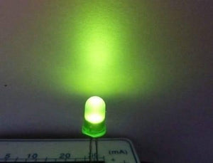 5mm Green Diffused LED Light Emitting Diode - glowing green above a white surface with a partial scale labeled in mA.