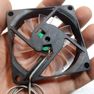 5V Fan With LED - a black square frame with translucent fan blades, a green circuit board at the center, and two attached wires.