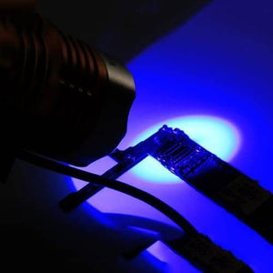 5V USB UV Glue Lamp LED Ultraviolet Green Oil Curing Purple Light - emitting a bright blue light onto a small electronic circuit board.