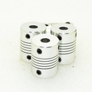 5x6mm Flexible Coupling Shaft With 25mm Outer Diameter - three silver cylindrical metal couplings with black set screws and spiral cutouts.