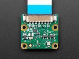 8MP Raspberry Pi Camera Module V2 - the green circuit board with a flat ribbon cable attached to the top connector on a dark background.
