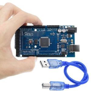 Arduino Mega 2560 R3 - held in a hand, featuring a blue circuit board with ports and buttons, accompanied by a blue USB cable.