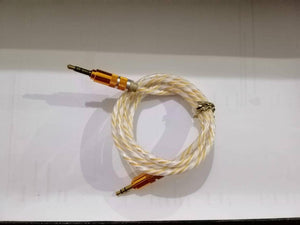 Aux Cable - a coiled white and yellow braided wire with gold-coloured 3.5mm connectors at both ends.
