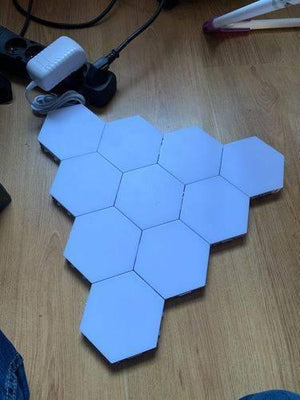 Blue Touch Light Wall Mount Magnetic Modular (1pc) - seven white hexagonal light panels connected together and plugged into a power adapter.