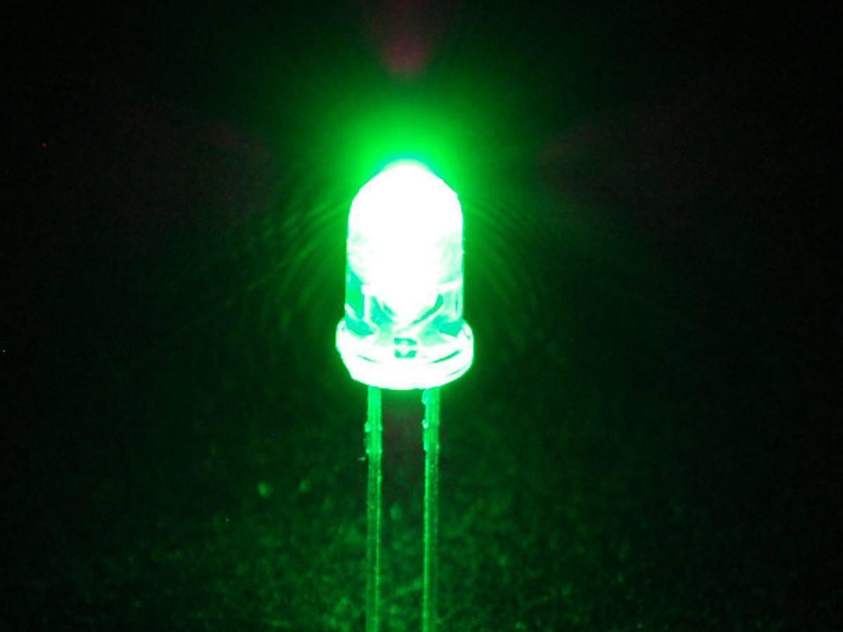 Crystal 5mm Green LED Light Emitting Diode - a clear, dome-shaped component emitting a bright green light with two metallic pins extending downwards.
