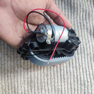 DC Gear Motor With 3.7V To 12V Operated - held in a hand, showing a silver cylindrical motor attached to a black plastic gearbox with red and black wires.