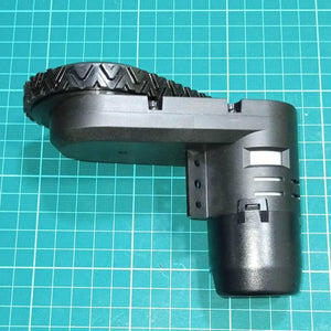 DC Gear Motor With Encoder With Wheel - a black motor assembly with an attached black rubber-treaded wheel resting on a green grid mat.