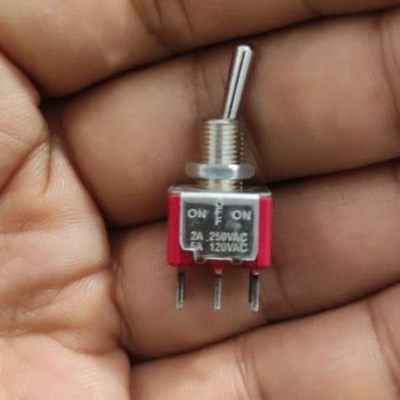 Dpdt 3 Positions Toggle Switch 6 Pin - shown as a close-up of a red and silver metal switch with three visible pins held in a hand.