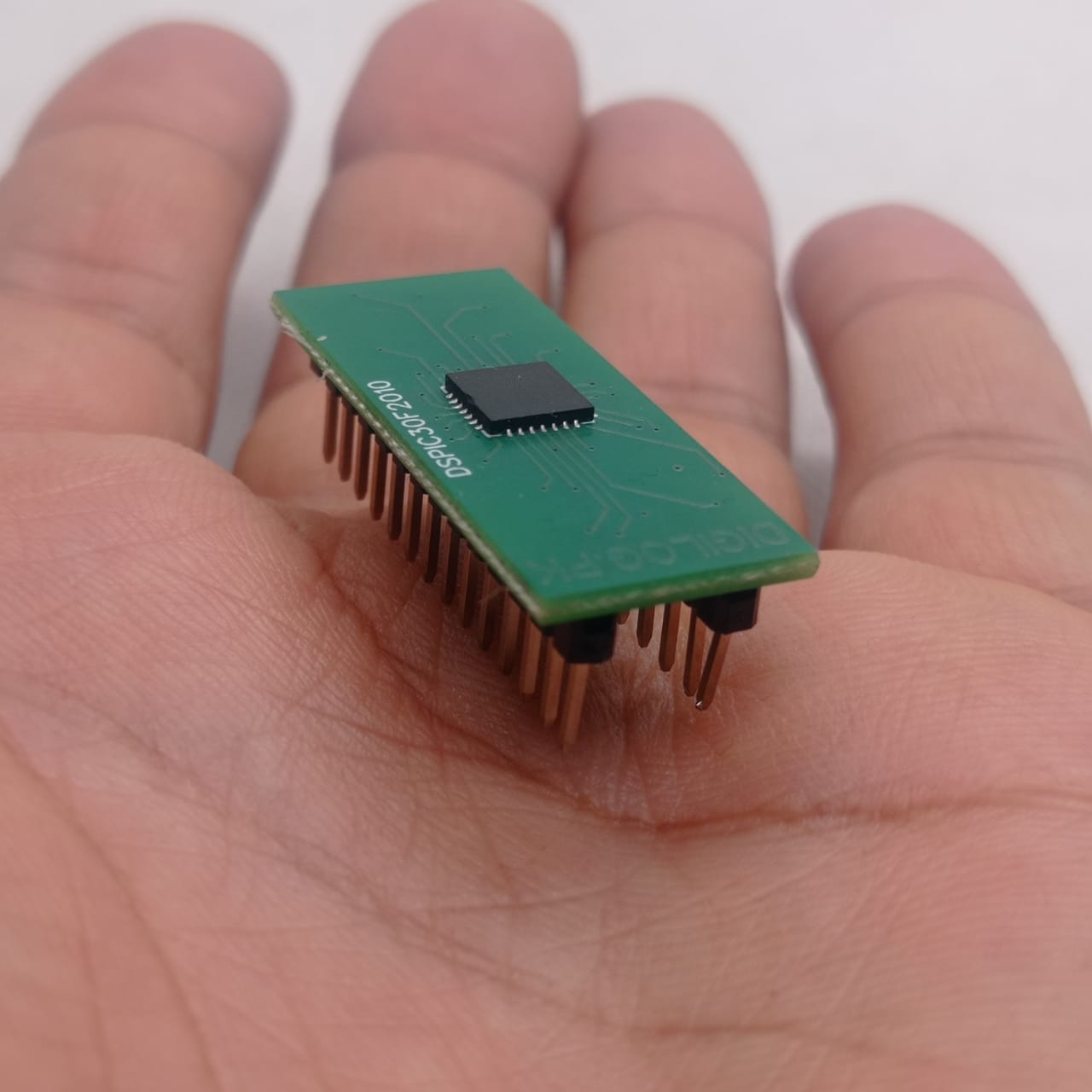 For Solar Inverter Inverter IC DSPIC30F2010 - shown as a green rectangular circuit board with a central black chip and two rows of metal pins held in a palm.