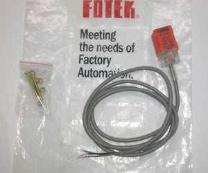 Fotek Proximity Sensor PL-05N 5mm NPN Out DC10-30V IP67 - shown with its grey cable, a small bag of mounting hardware, and the branded plastic packaging.