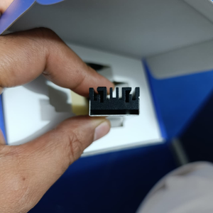 Ineo M.2 Heatsink SSD Cooler With 20mm Cooling Fan - Model C2600-II For Nvme 2280 SSD - a close-up view of the black metal heatsink held by fingers, showing its grooved profile and silver base.