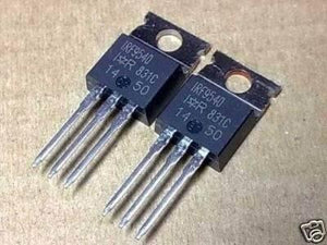 IRF9540 p Channel Power MOSFET - Buy Power MOSFET | Digilog.pk - two black, three-pin electronic components with metal mounting tabs arranged side-by-side on a brown surface.