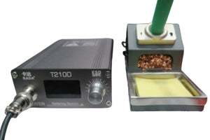 Kada T210D Thermostatic Soldering Station – 75W, Adjustable Temperature 120–450°c, LED Display, Auto Sleep, Pid Control - with a black control unit featuring a display and knob, next to a stand with a brass tip cleaner and yellow sponge.