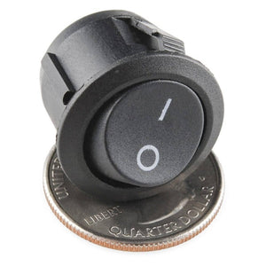 Kcd-107 Spst Round Rocker Switch Button - a black circular rocker switch with an on-off symbol, shown resting on top of a US quarter coin.