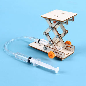 Kids DIY Hydraulic Lift Table Model Scientific Experiment Kit Educational STEM Toy - a wooden scissor lift mechanism connected by a plastic tube to a handheld syringe.