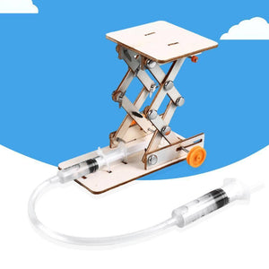 Kids DIY Hydraulic Lift Table Model Scientific Experiment Kit Educational STEM Toy - a wooden scissor lift mechanism connected by a plastic tube to a syringe, with a second syringe detached.