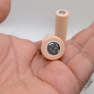 LGAAHD2C1865 3.7V 2100mAh High-drain 18650 Li-ion Battery - a close-up view of two peach-colored cylindrical batteries held in a hand.
