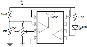 LM393 Dual Differential Comparator IC - an LDR, a 10K potentiometer, an LED, and resistors connected to an LM393 chip.