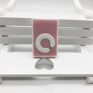 MP3 Music Player With Handsfree - a small, pink, rectangular digital music player with a white circular control pad featuring playback and volume icons.