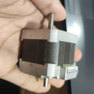 NEMA 17 Stepper Motor Dual Shaft Model B-2381715B - shown held in a hand, featuring a black square body, silver end caps, dual shafts, and a white connector.