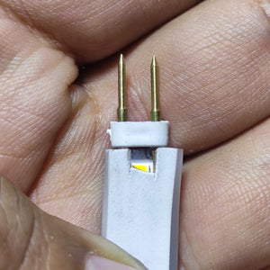 Neon Light Connector Pin - a close-up view of a white plastic connector with two gold-colored metal pins inserted into a white neon light strip.