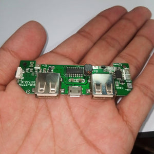 Pull Out 5V 2A DIY Power Bank Module With Emergency Light Points - green circuit board held in a hand, featuring two USB ports, a micro-USB port, and a button.