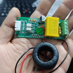 PZEM-004T 100A Single Phase Power Energy Meter Module - a green PCB, a yellow capacitor, a white connector, and a black current transformer coil.