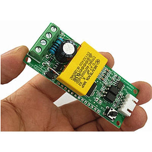 PZEM-004T 100A Single Phase Power Energy Meter Module - held in a hand, showing a green circuit board with a yellow capacitor, screw terminals, a white connector, and a black button.