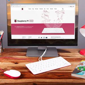 Raspberry Pi 400 4GB RAM Your Complete Personal Computer, Built Into a Compact Keyboard-digilog.pk - a white and red compact keyboard computer connected to a monitor displaying the Raspberry Pi website, with a matching mouse.