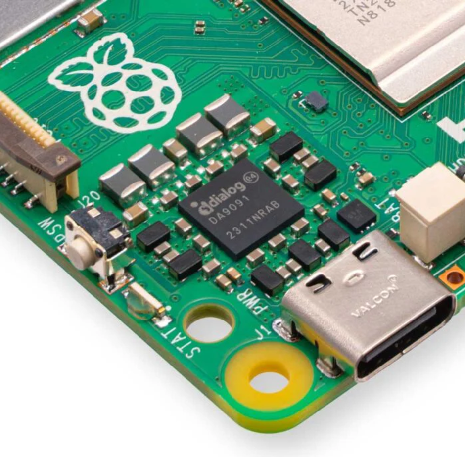 Raspberry Pi 5 8GB RAM - a close-up view of the green circuit board showing the Dialog DA9091 chip, a USB-C port, a power button, and status labels.