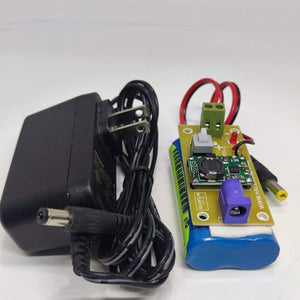 Rechargeable Battery Pack For Arduino And Robot Power Supply With Charger - a blue battery pack with a circuit board, switch, and power adapter.
