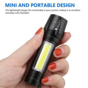 Rechargeable COB Light Flashlight - held in a hand, showing a black cylindrical body with a side COB light panel and a zoomable head with marked settings.