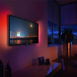 RGB LED Strip 30 LED Per Meter 5 Meter Roll 5050 Size 12V - 12V installed behind a wall-mounted television, casting a red ambient glow on the wall.