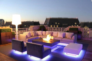 RGB LED Strip With Remote And Power Supply White Background 12V 5meter 24 Key Remote - rooftop patio lounge area features modern furniture illuminated from below by glowing blue LED strips.
