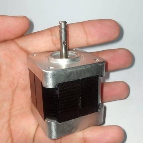 Round Shaft NEMA17 Stepper Motor For 3d Printer & CNC - a silver metal square base with a black stacked core and a vertical metal shaft held in a hand.