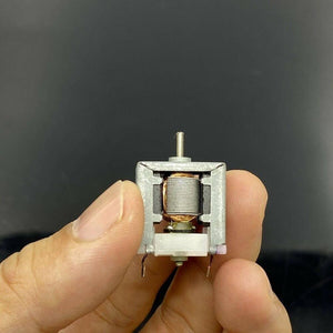Sc-020 5V DC Motor 3V-9V Brush DC Motor DIY Science Experiment Motor - a close-up view of a small silver-cased brush motor with a visible copper wire coil held between fingers.