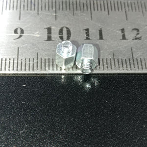 Screw Standoffs Spacers M3 Male x M3 Female - shown in a close-up view next to a metal ruler to indicate their size.