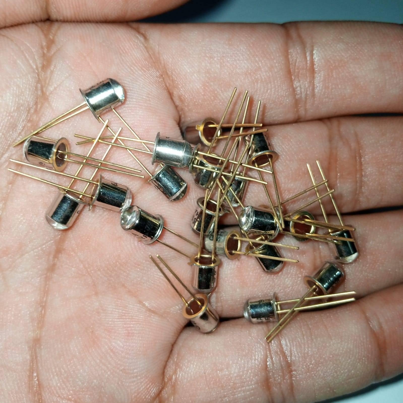 Sharp Infrared Emitting LED Diode GL514A - shown as a small pile of silver metal-can components with two gold-coloured pins held in a person's palm.