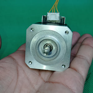 Shinano Kenshi STP-42D4042 2A 1.8 Degree Per Step 0.53nm Stepper Motor - a silver square-bodied motor with a central shaft and a white electrical connector with yellow wires.